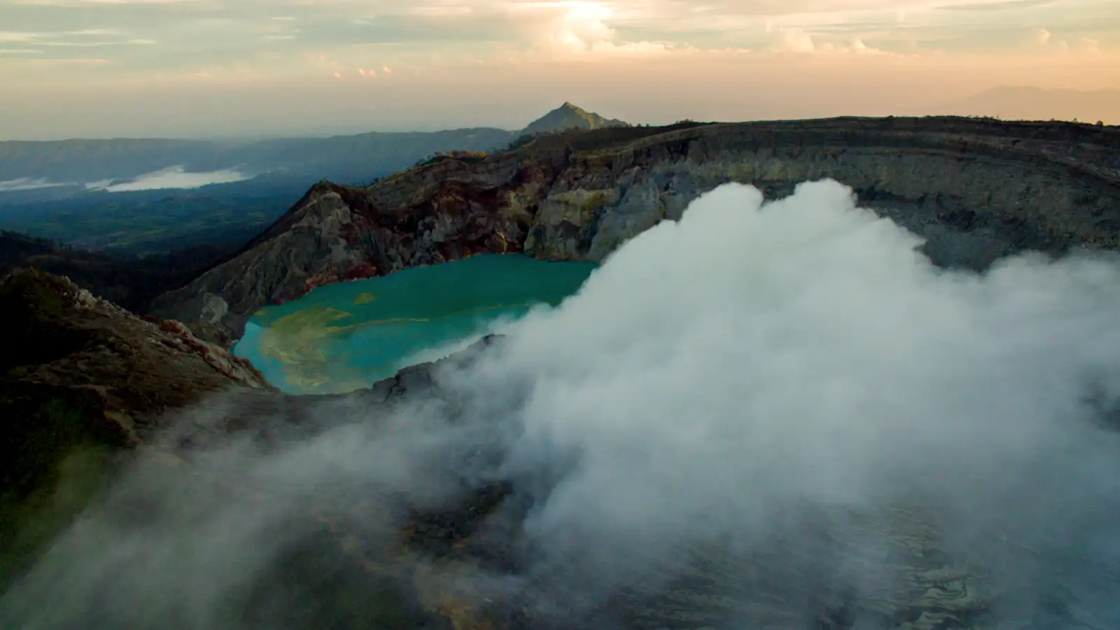 The turquoise acidic lake of Ijen Crater during the morning golden hour