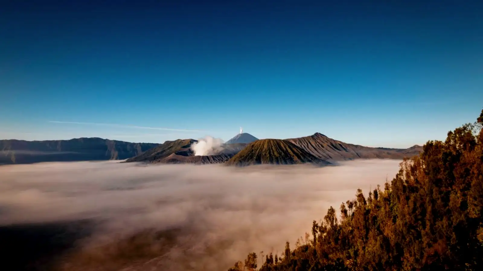 Close-up of the smoking Mount Bromo crater with blue sky