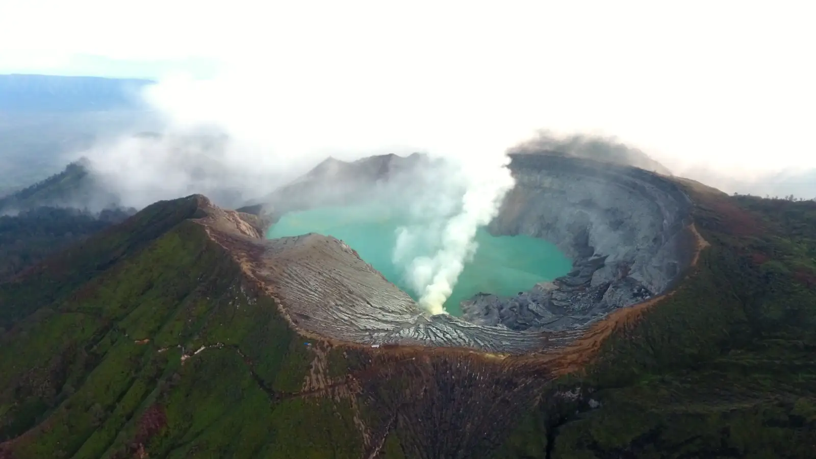 Turquoise acid lake at Ijen Crater during sunrise