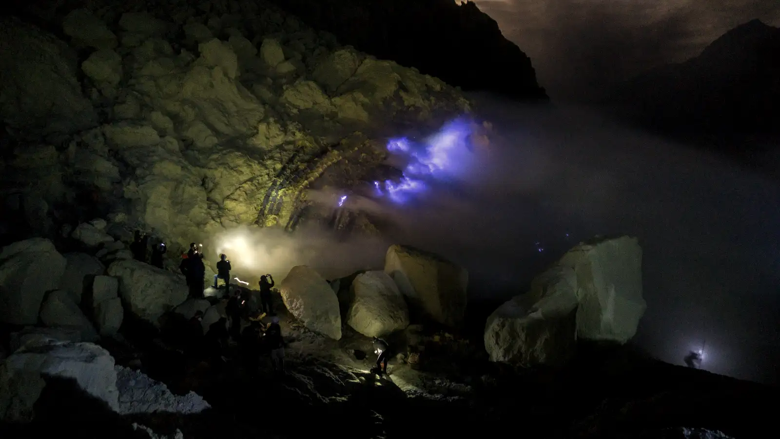 Guided Ijen Trekking A professional tour guide leading hikers up the slopes of Mount Ijen