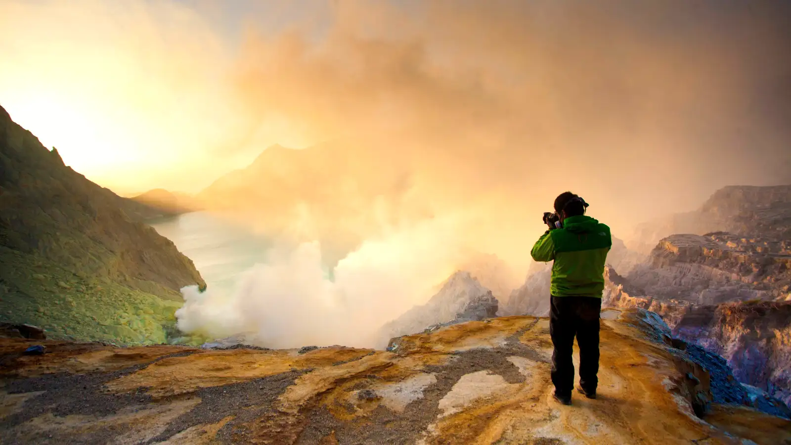 Ijen Crater sunrise view with turquoise acidic lake and volcanic steam