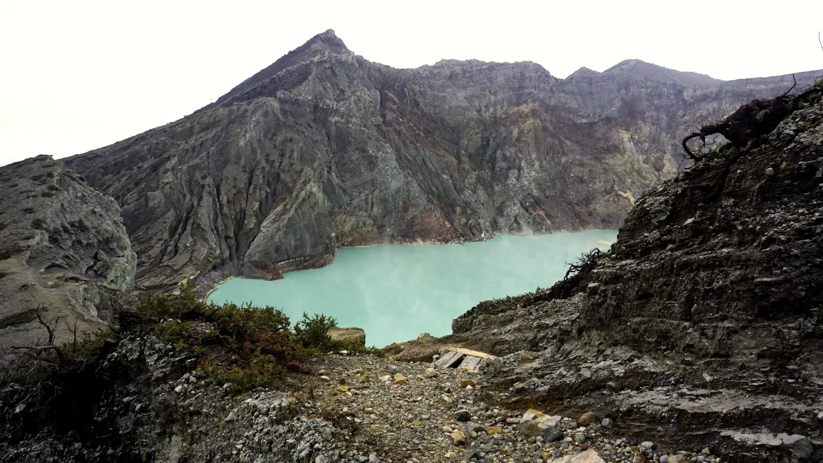 Hikers standing on the rim of Ijen Crater with the lake below showing dimensions