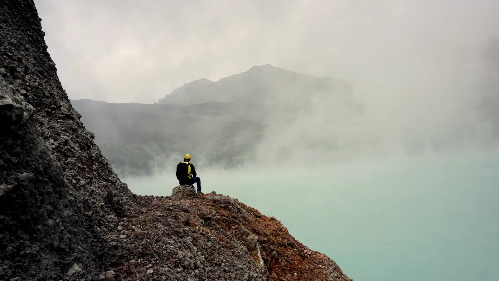 Stunning sunrise view over the turquoise acid lake of Ijen Crater rim