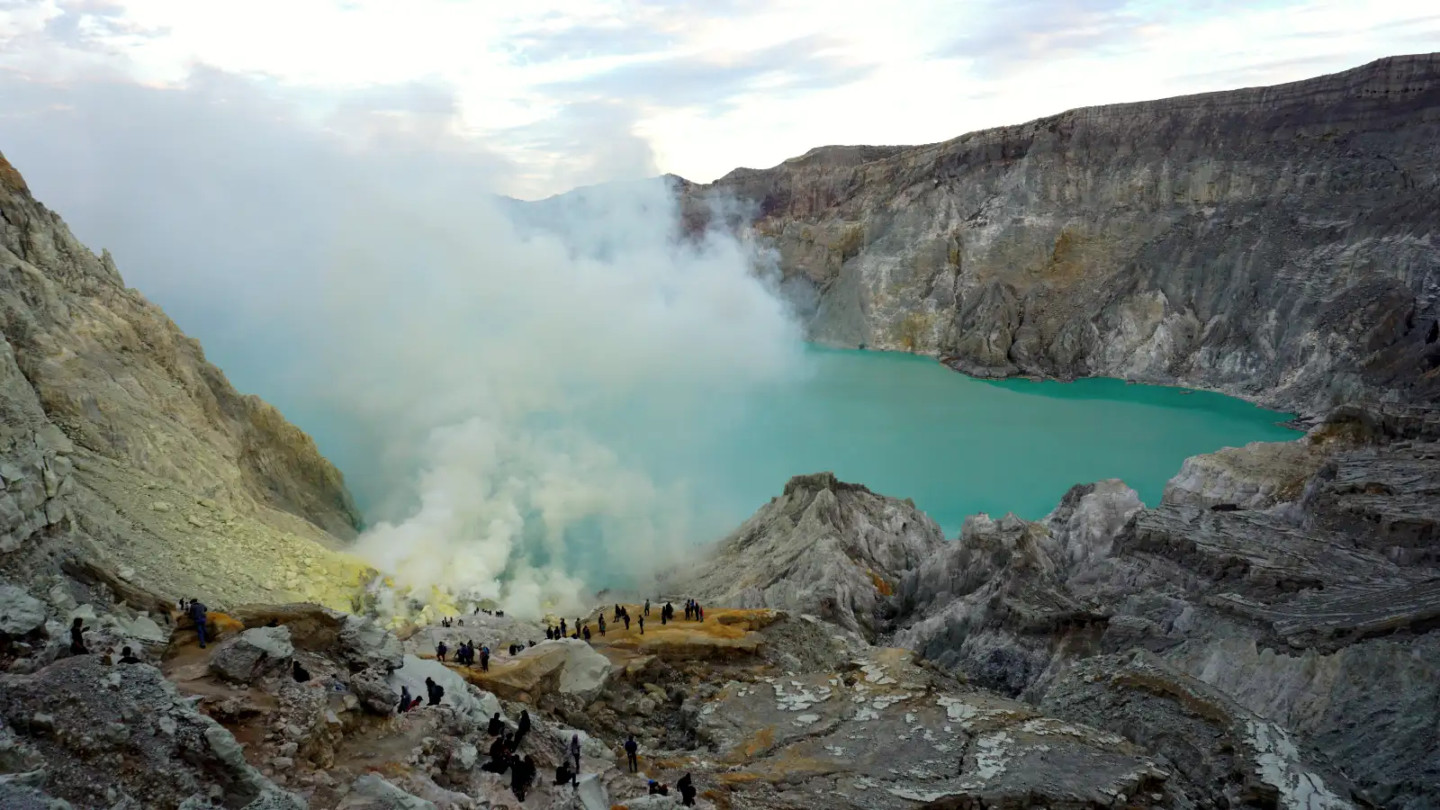 Hikers standing on the rim of Ijen Crater during sunrise