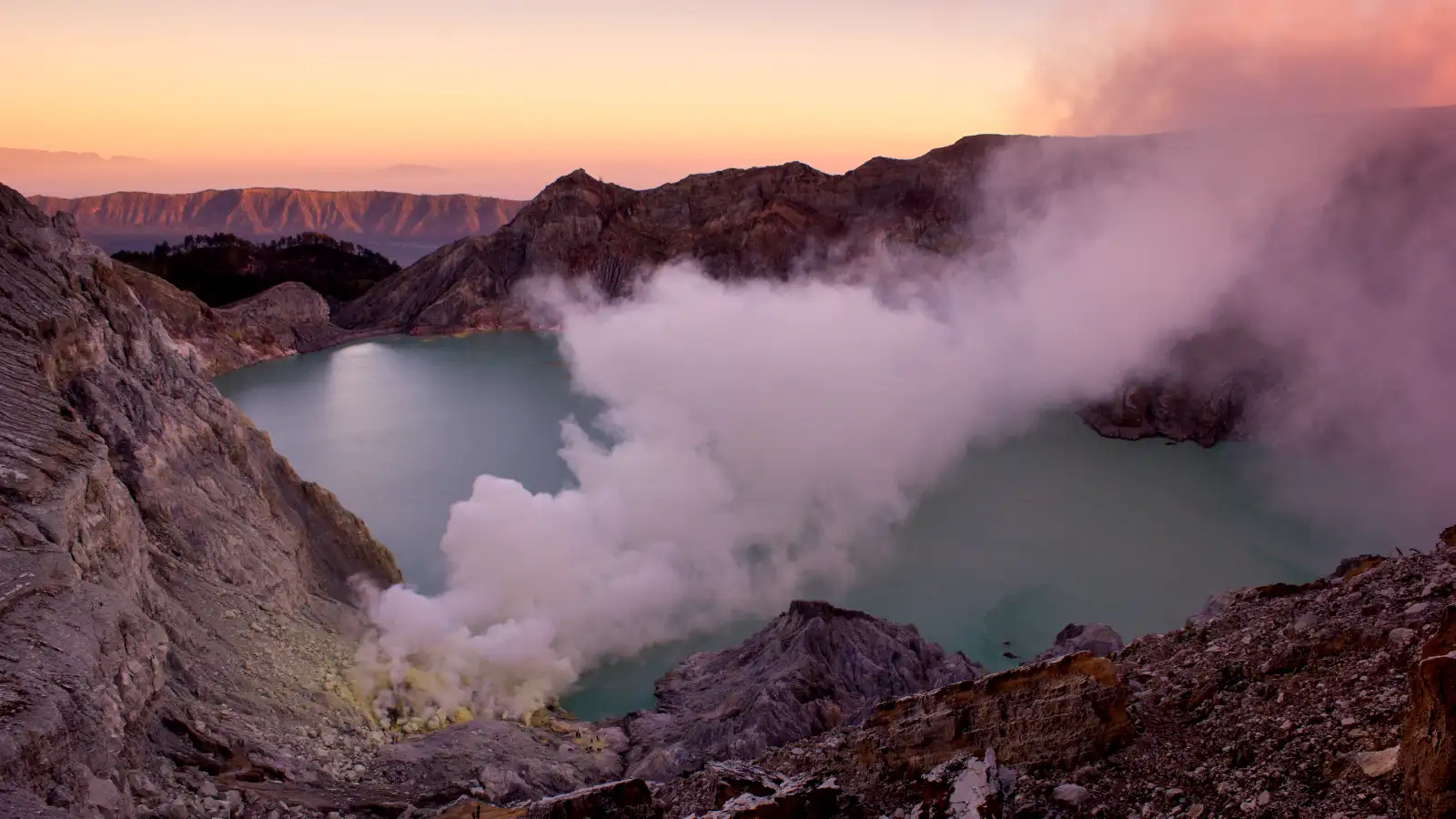 Stunning view of the turquoise acidic lake at Ijen Crater during sunrise