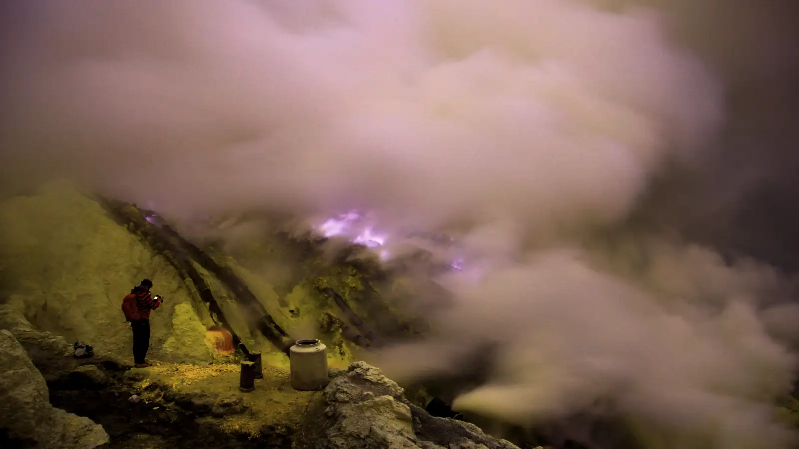 Local sulfur miner carrying heavy loads of yellow sulfur rocks at Ijen