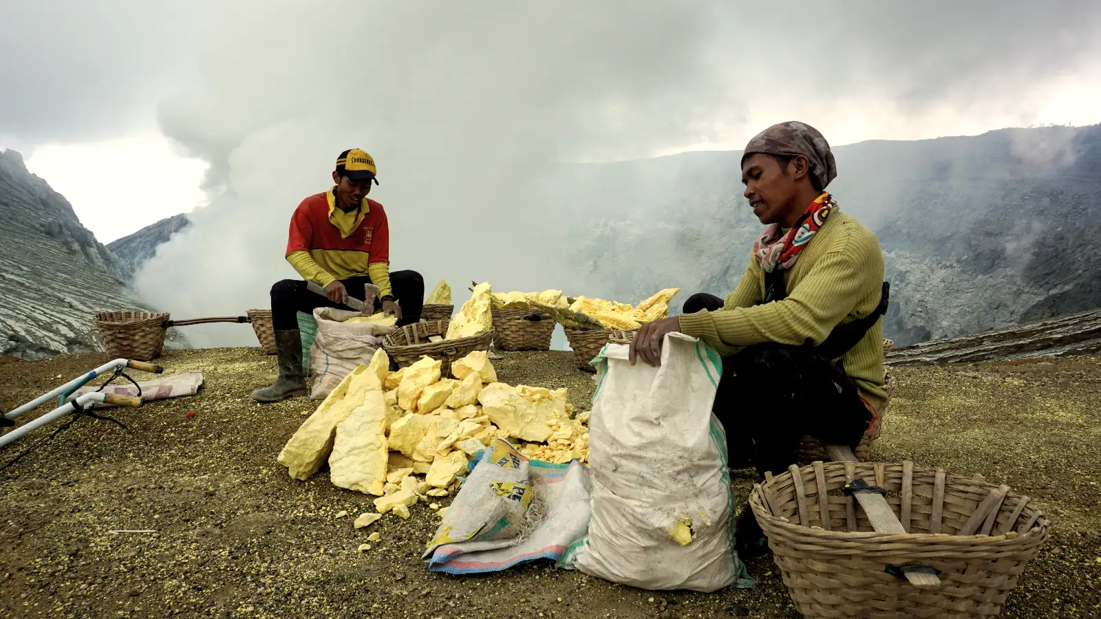Miners weighing their sulfur loads at the weigh station halfway up the volcano