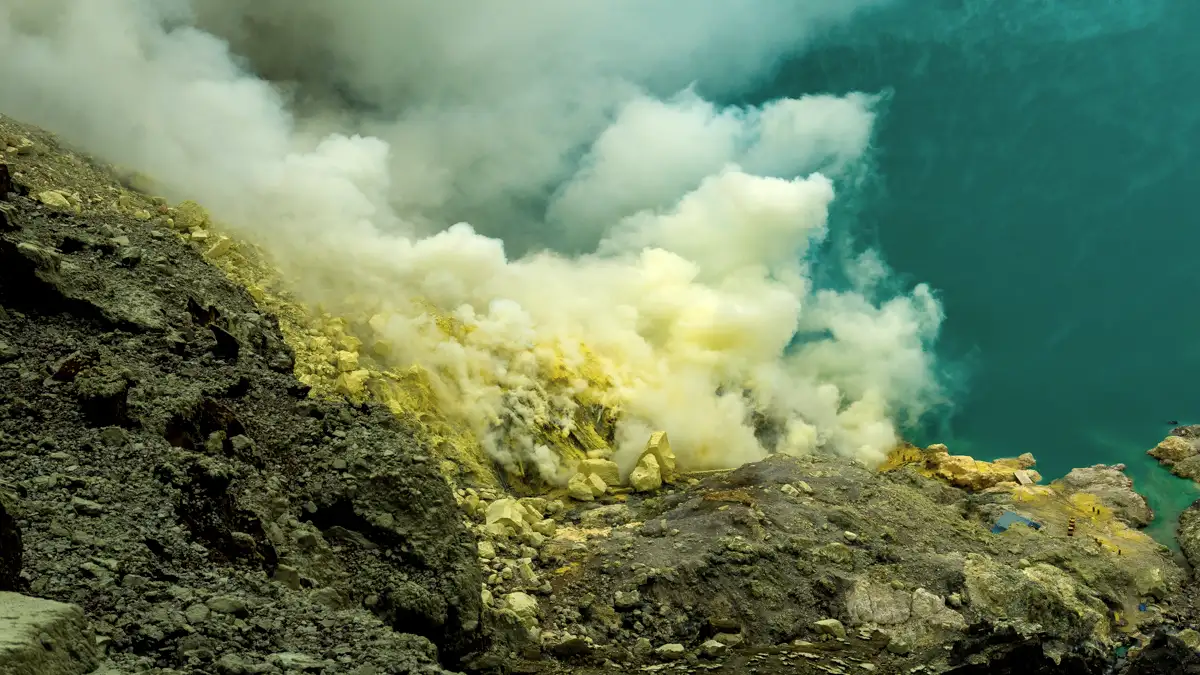 Sulfur miners carrying heavy baskets under the current visitor regulations at Ijen